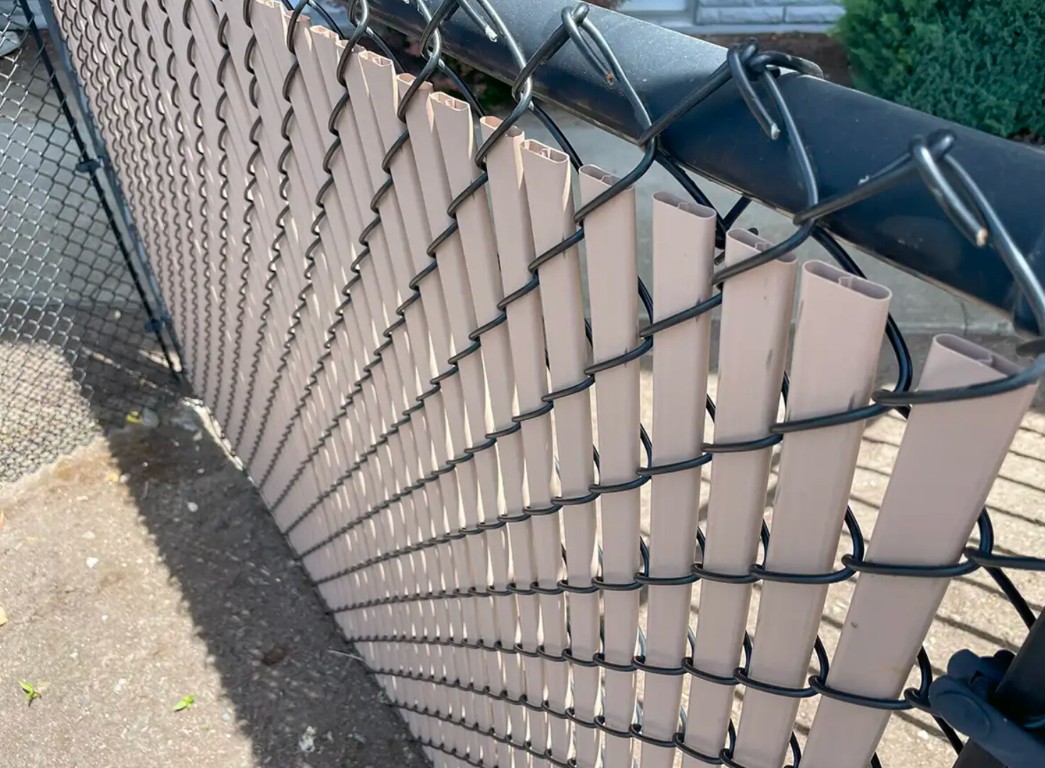 Chain-link fence with privacy slats installation